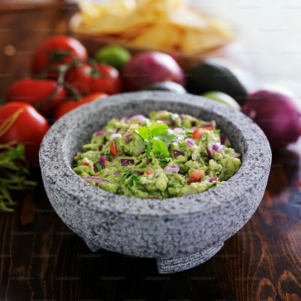 granite molcajete and mexican guacamole with vegetables, shot with selective focus