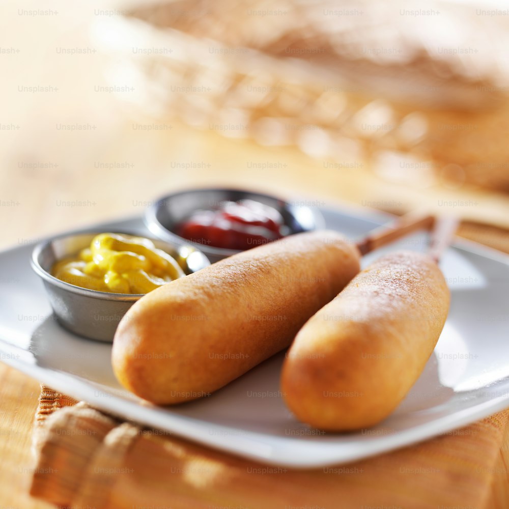 corn dogs with ketchup and mustard on plate, shot with selective focus