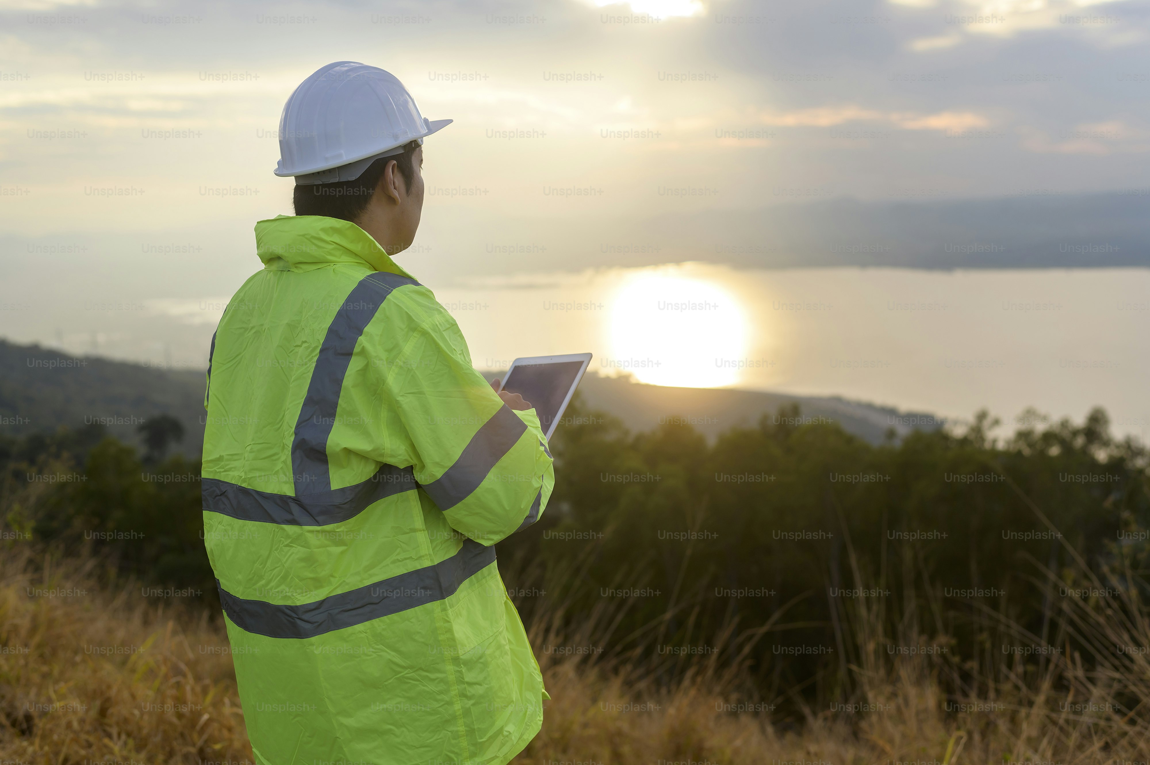 Ein Ingenieur trägt einen Schutzhelm auf dem Kopf und verwendet technische Daten von Tablet Analytics.