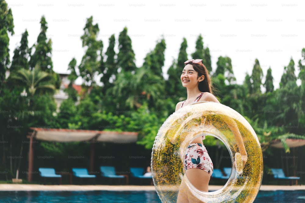 Southeast asia holidays summer travel concept. Happy smile young adult asian woman at hotel swimming pool. People with satisfaction life moment at nature outdoor.