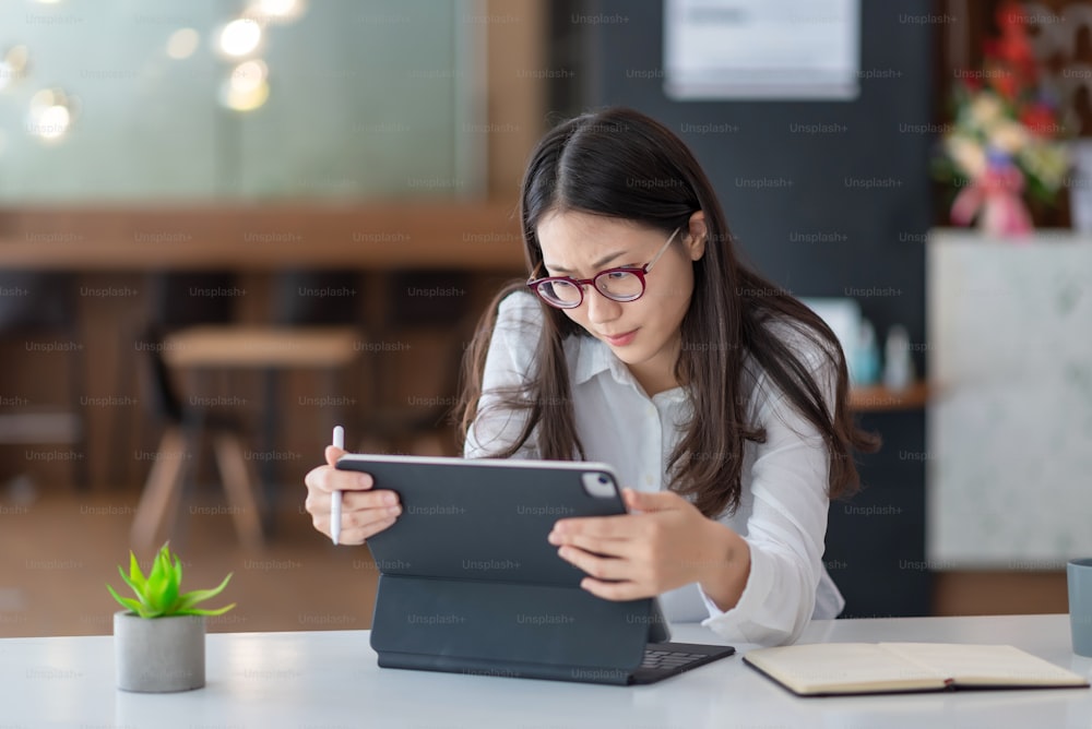 Asian businesswoman are Shocked and stressed about their work tablet at the office.