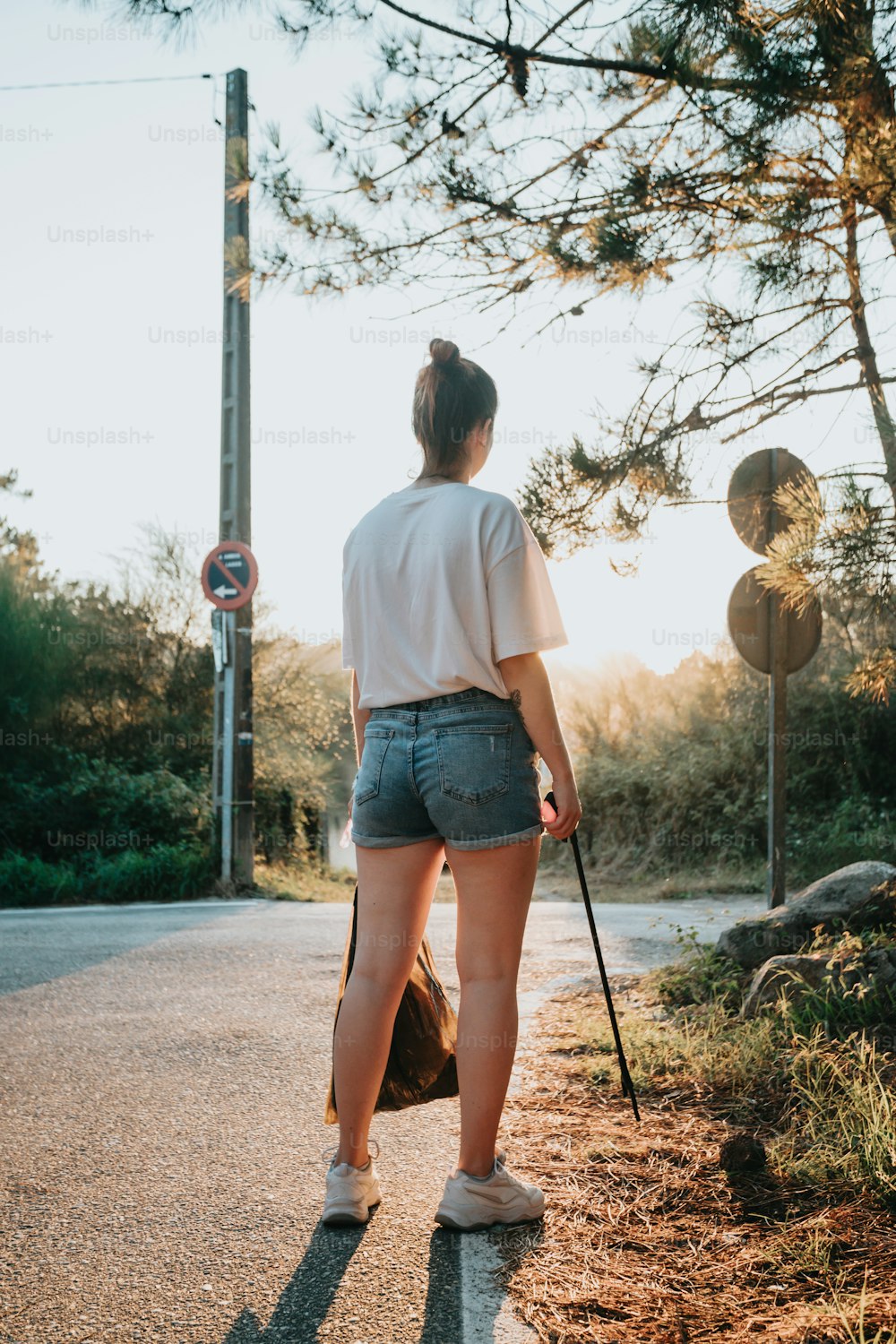 a woman walking down a road with a cane