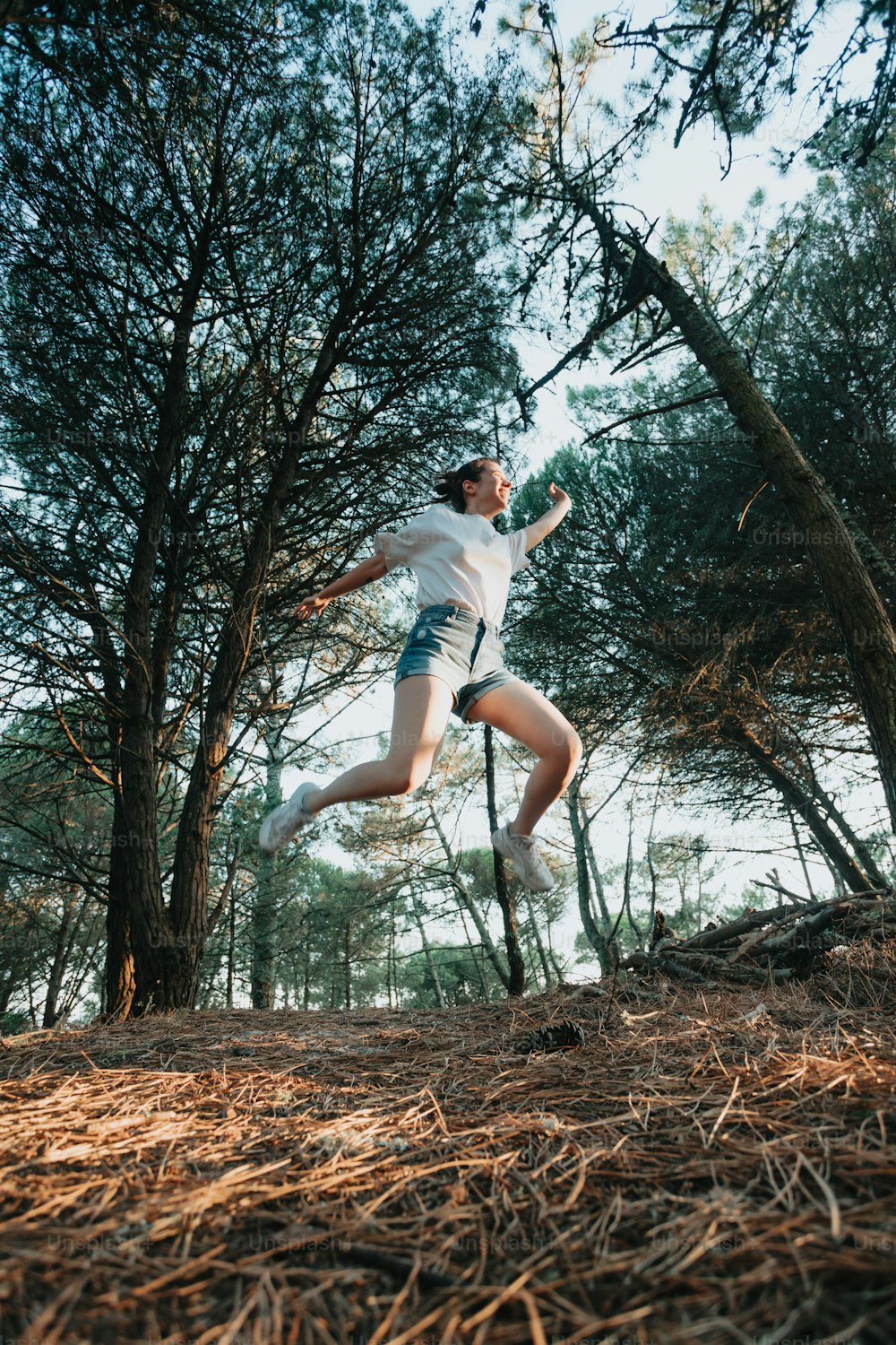 um homem pulando no ar na floresta