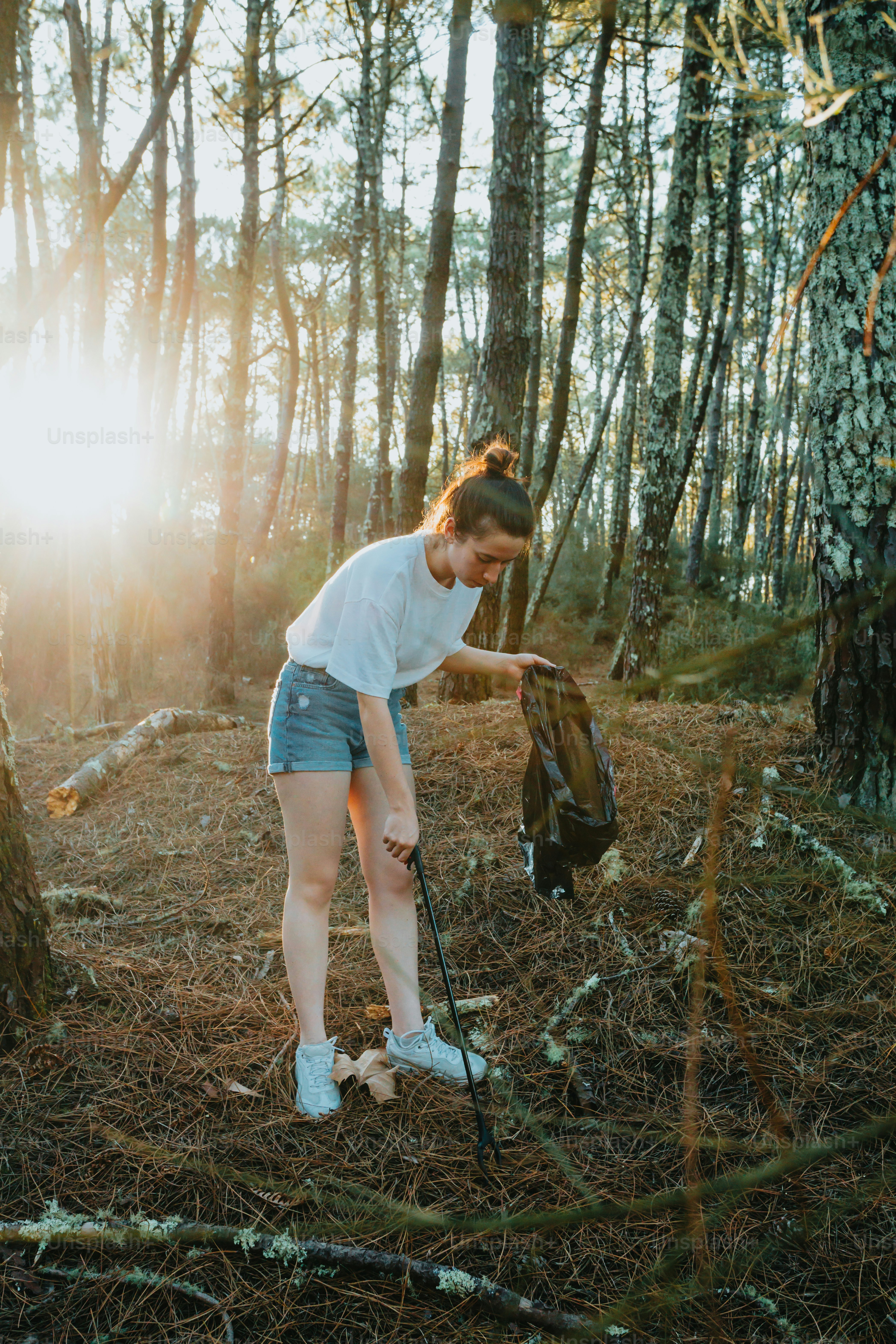 uma mulher em pé na floresta com uma mochila