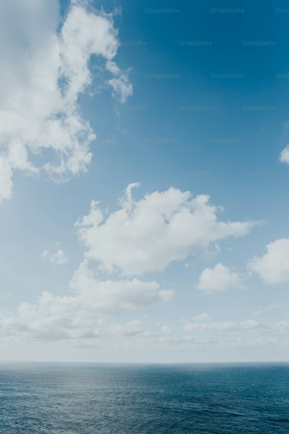 a large body of water under a cloudy blue sky