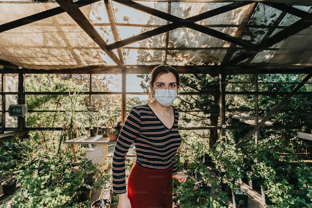 a woman wearing a face mask in a greenhouse