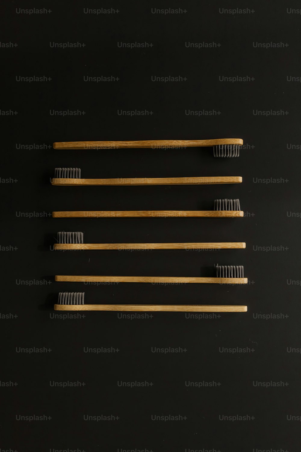 four toothbrushes lined up on a black surface