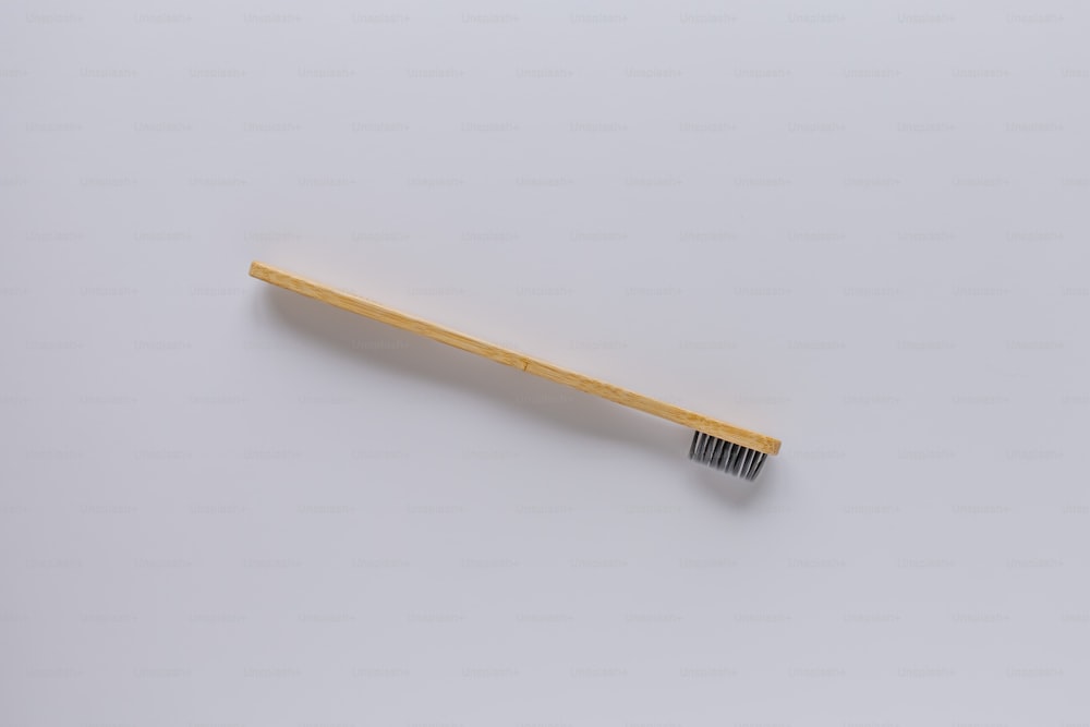 uno spazzolino da denti di legno su sfondo bianco