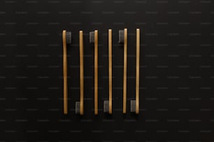 three wooden toothbrushes on a black surface