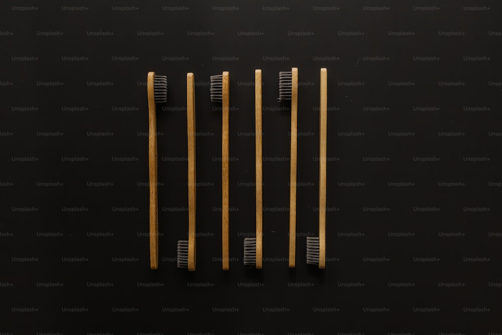 three wooden toothbrushes on a black surface