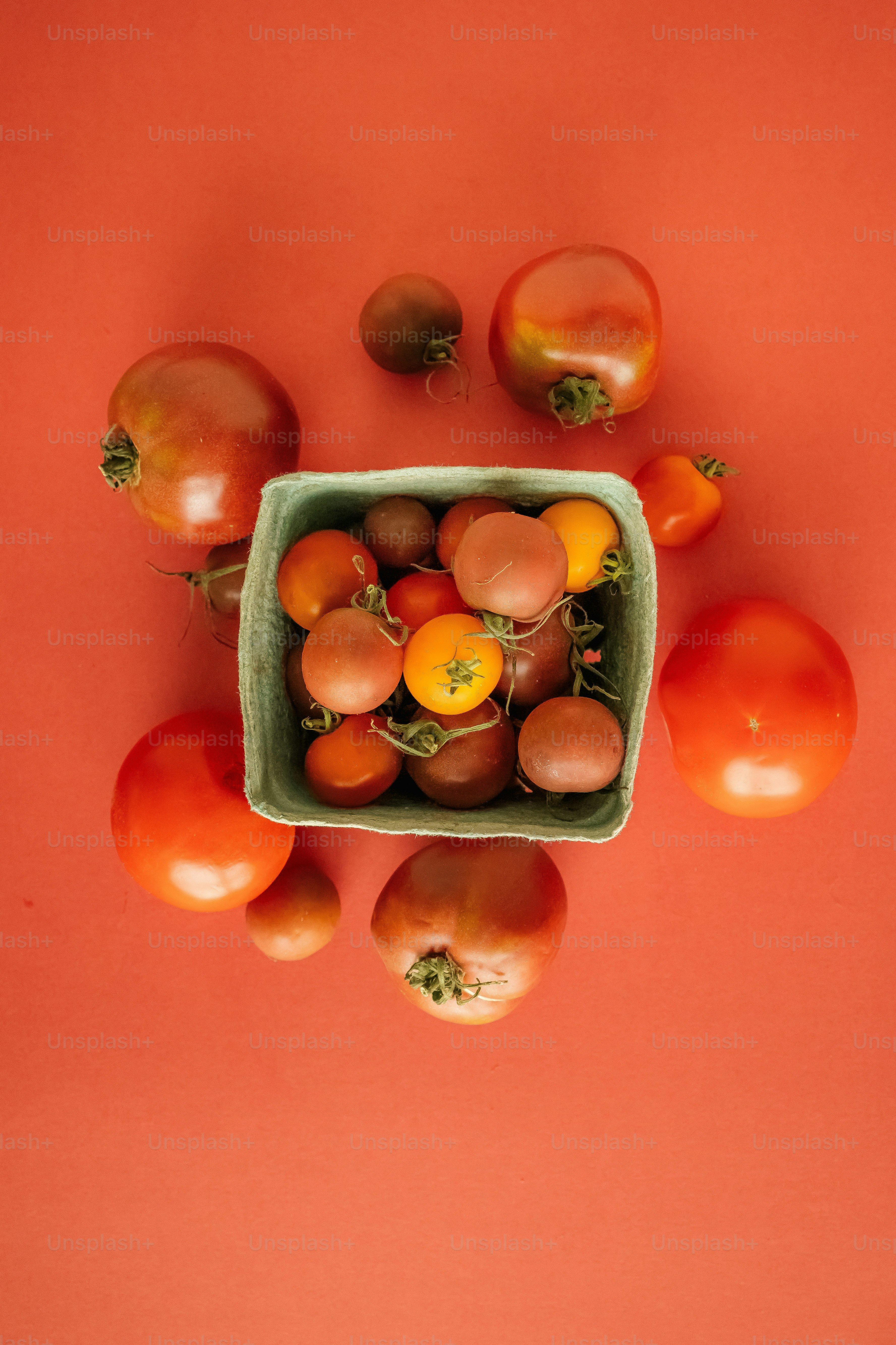 a green bowl filled with lots of tomatoes