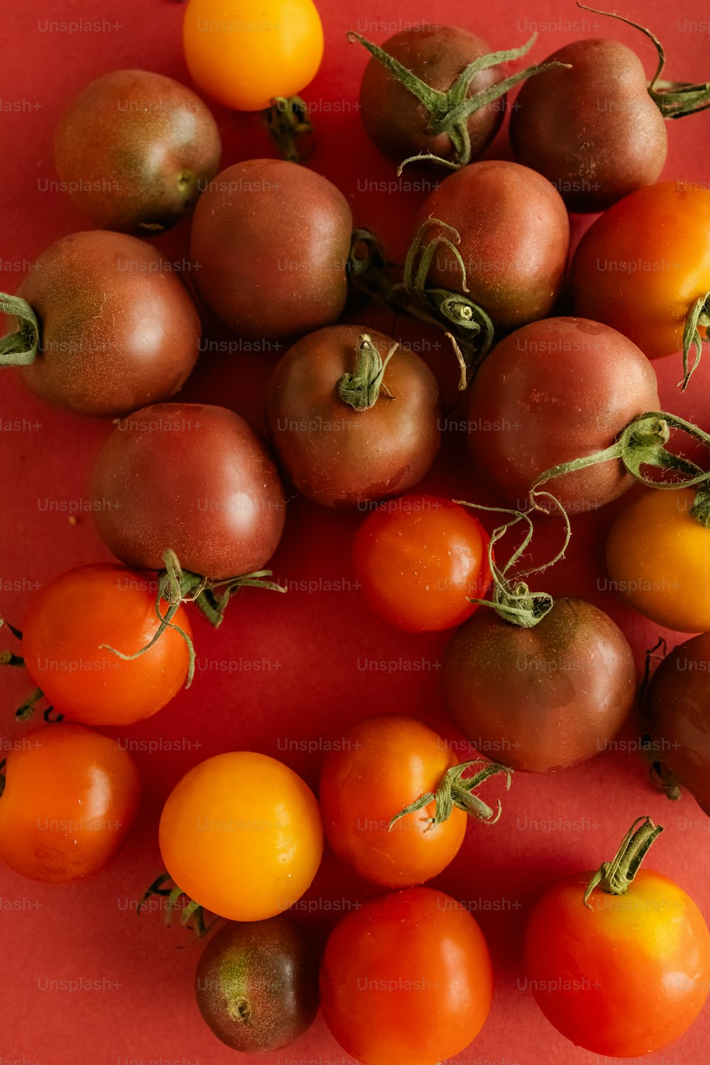 un bouquet de tomates sur une surface rouge