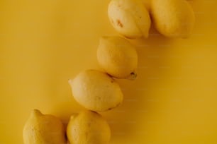 黄色い表面の上に座っているレモンのグループ