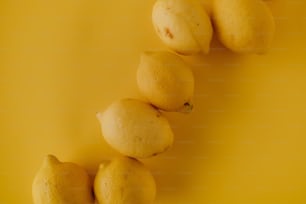 a group of lemons sitting on top of a yellow surface