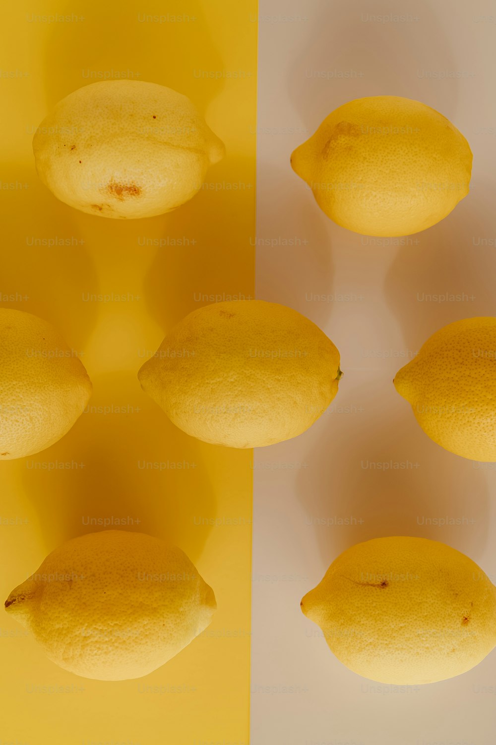 a group of lemons on a yellow and white background