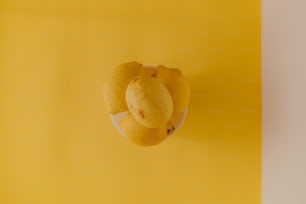 ein gelber Hintergrund mit einem Teller mit Früchten darauf