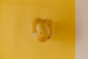 a yellow background with a plate of fruit on it