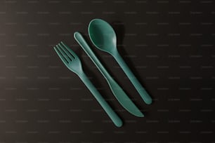 um par de garfos e uma colher sobre uma mesa