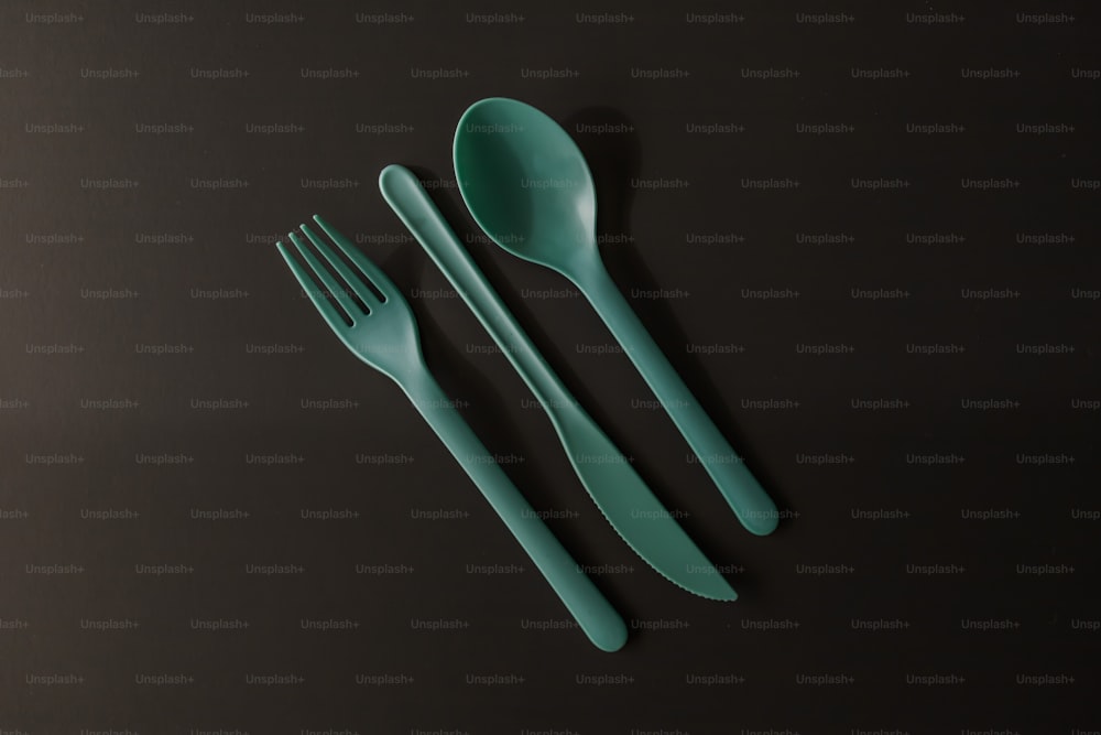 a couple of forks and a spoon on a table
