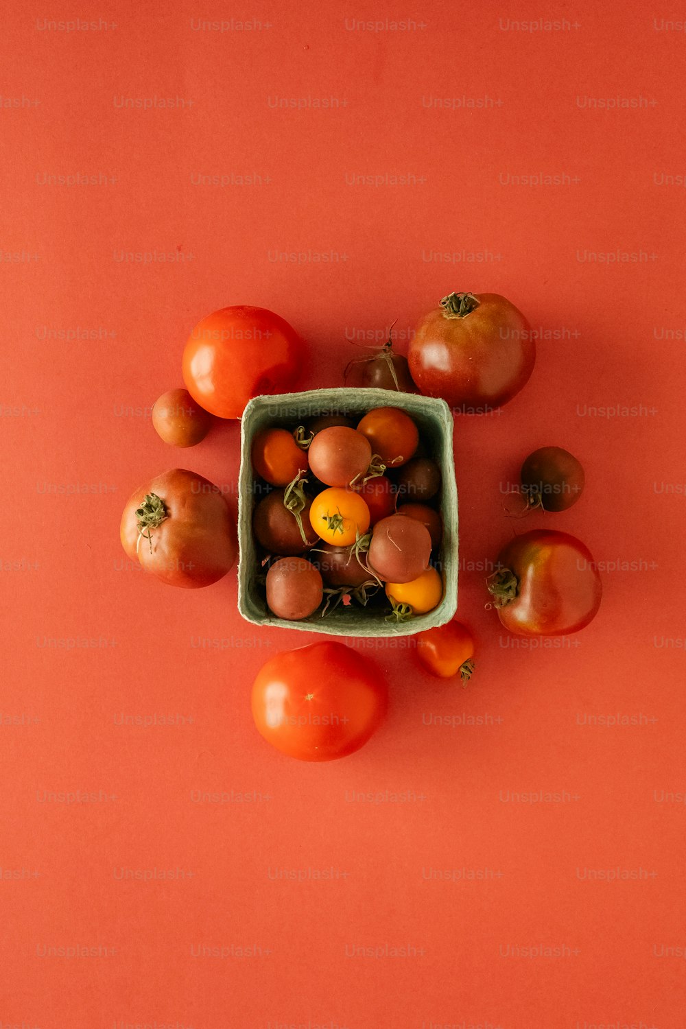 a bowl of tomatoes on a red surface
