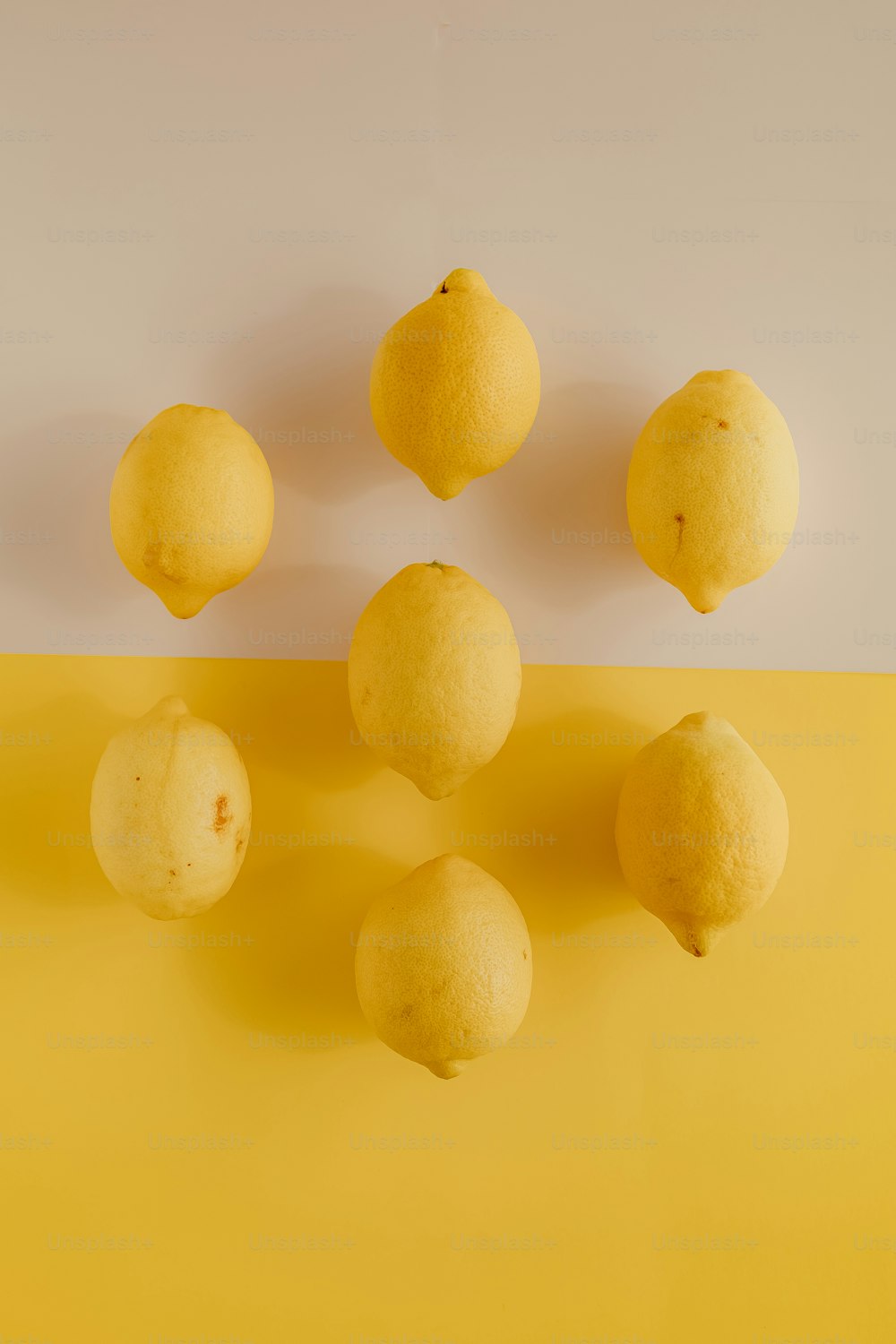노란 테이블 위에 앉아 있는 레몬 한 무리