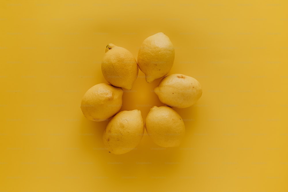 노란색 표면 위에 앉아 있는 레몬 그룹