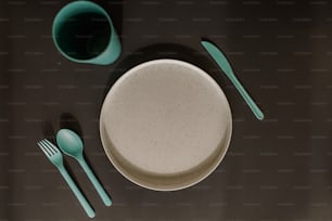 un tavolo con un piatto, una forchetta, un cucchiaio e una tazza
