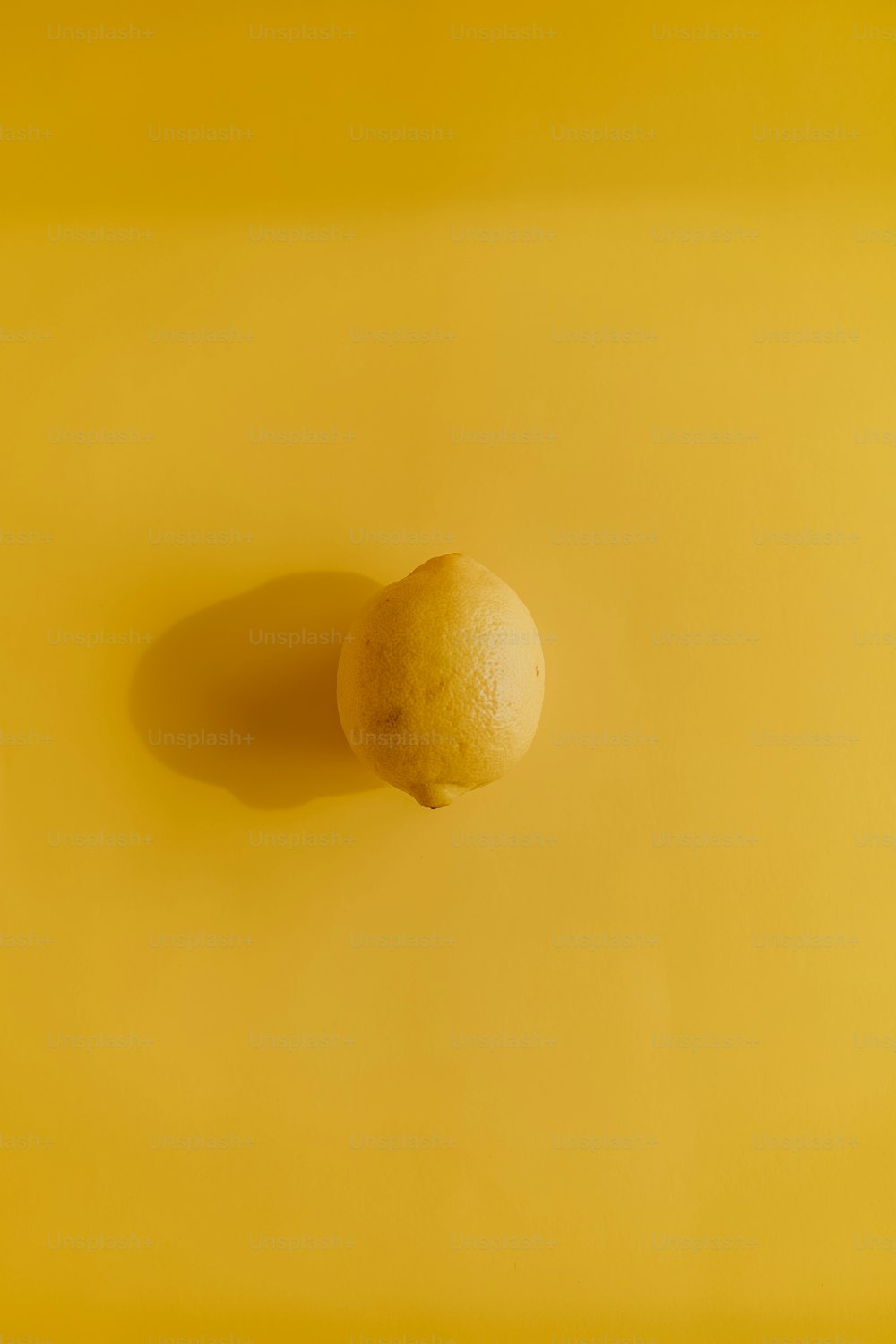 노란색 표면 위에 앉아있는 레몬