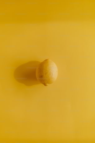 a lemon sitting on top of a yellow surface