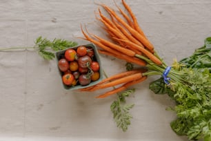 a bunch of carrots and tomatoes on a table