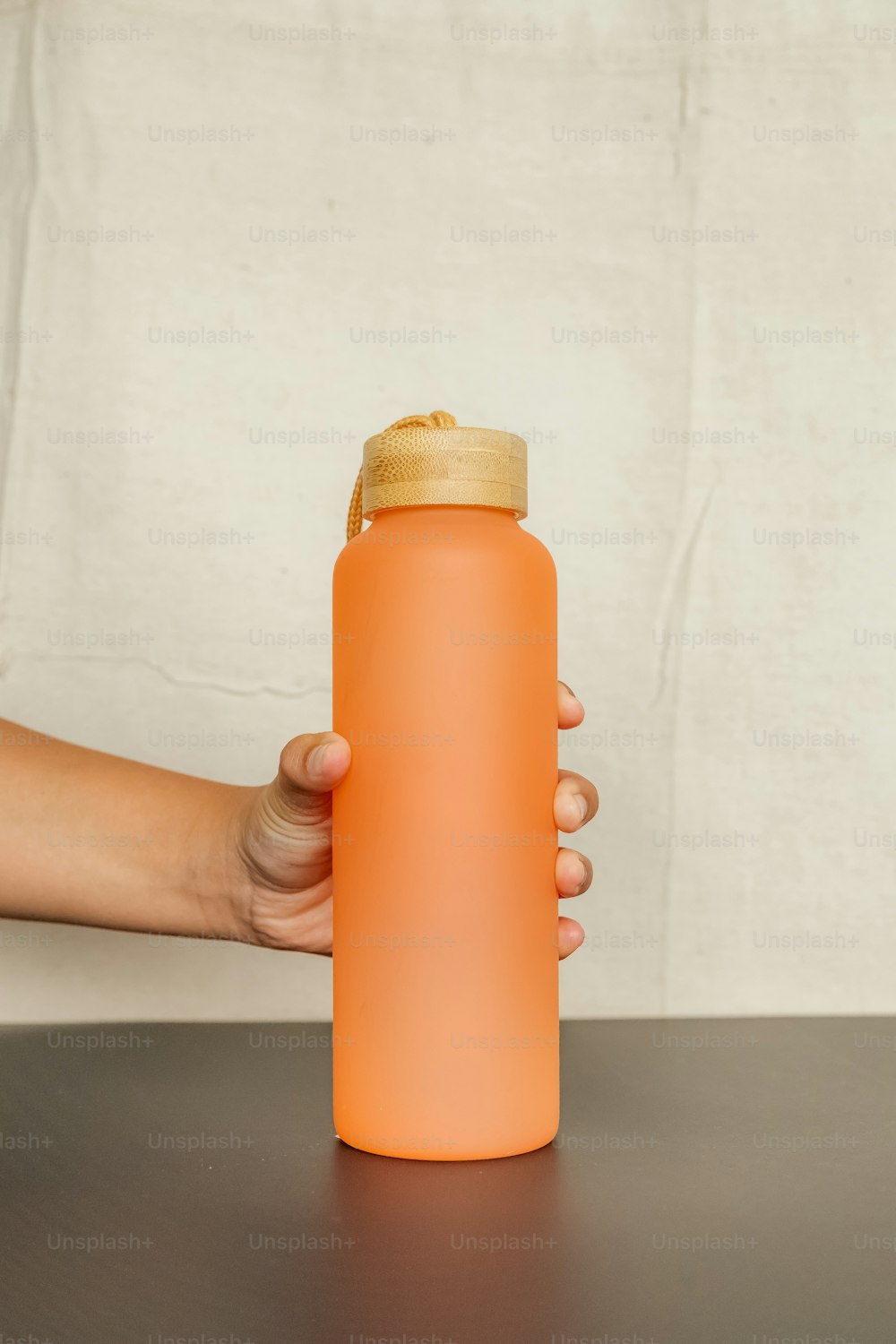 a person holding a water bottle on a table