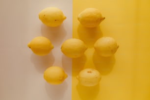 un groupe de citrons assis sur une table jaune et blanche