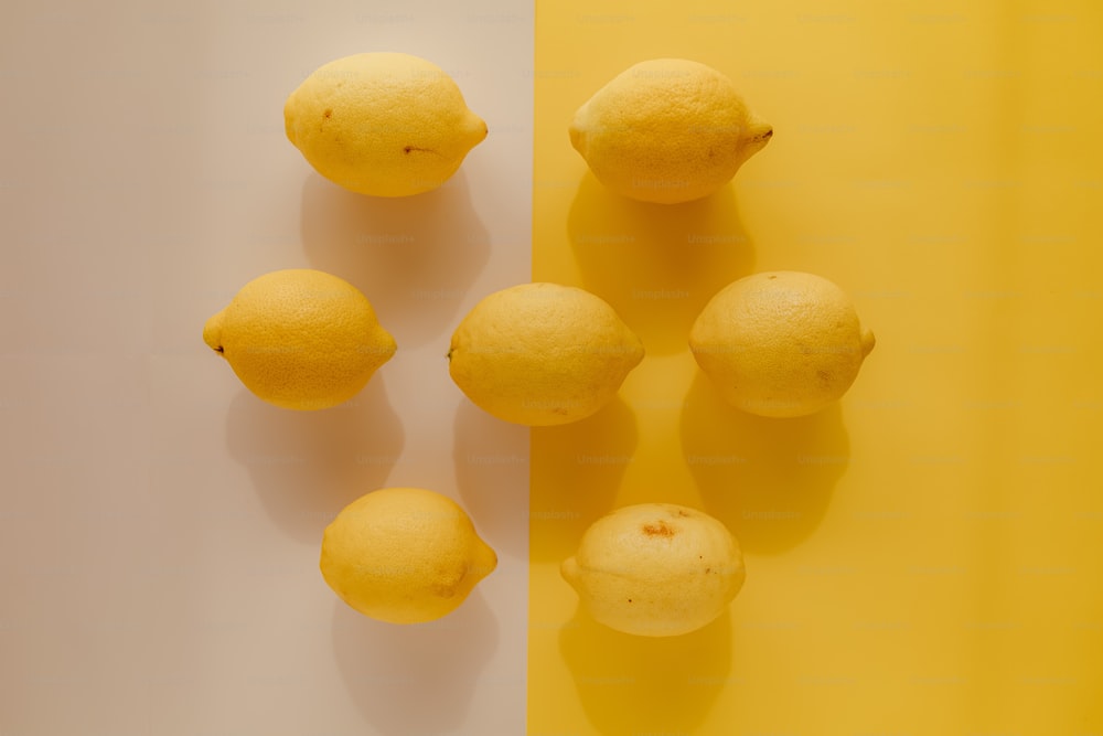 um grupo de limões sentados em cima de uma mesa amarela e branca