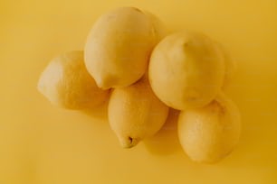 un gruppo di limoni seduti sopra una superficie gialla