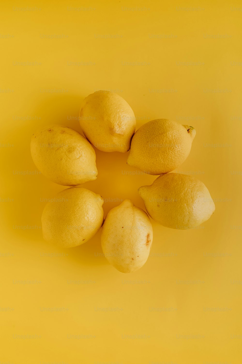 a group of lemons sitting on top of a yellow surface