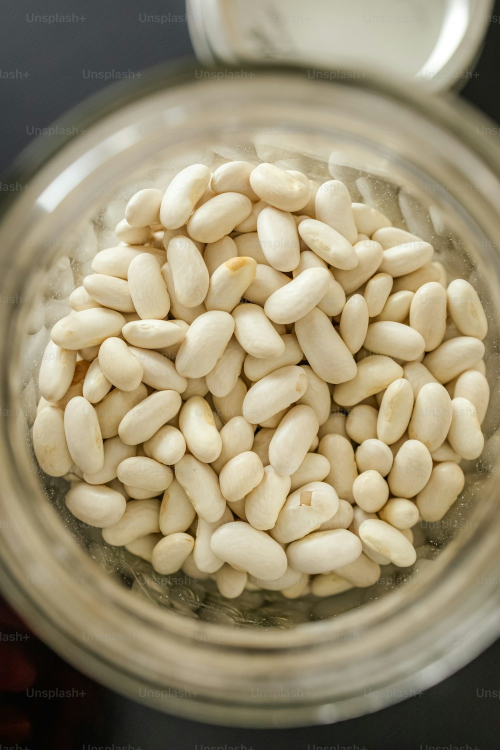 a jar filled with white beans sitting on top of a table