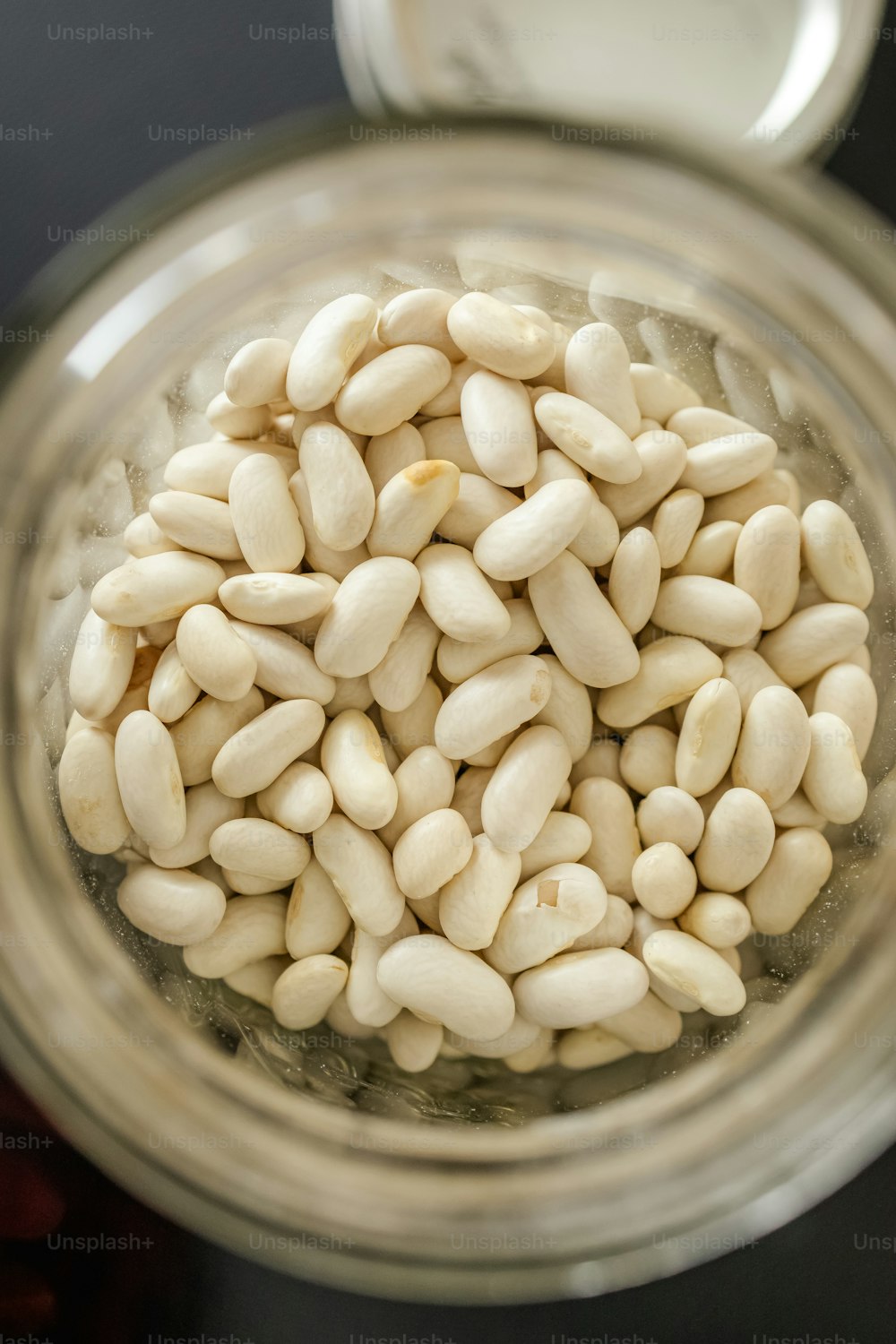 un pot rempli de haricots blancs posé sur une table