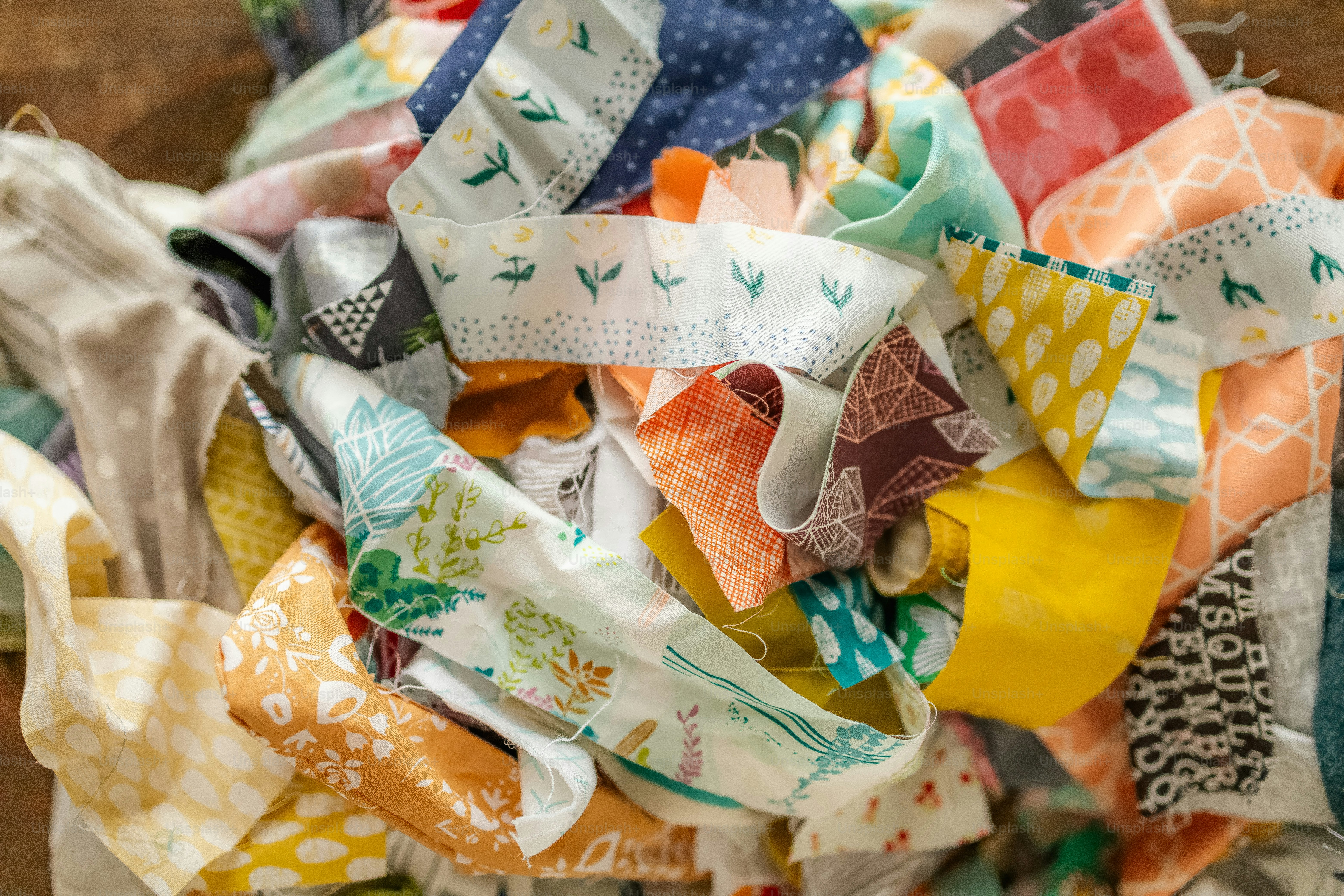 a pile of colorful cloths sitting on top of a wooden table