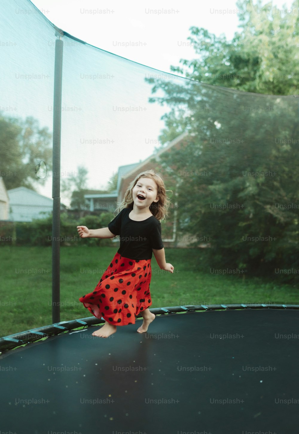 a little girl that is standing on a trampoline