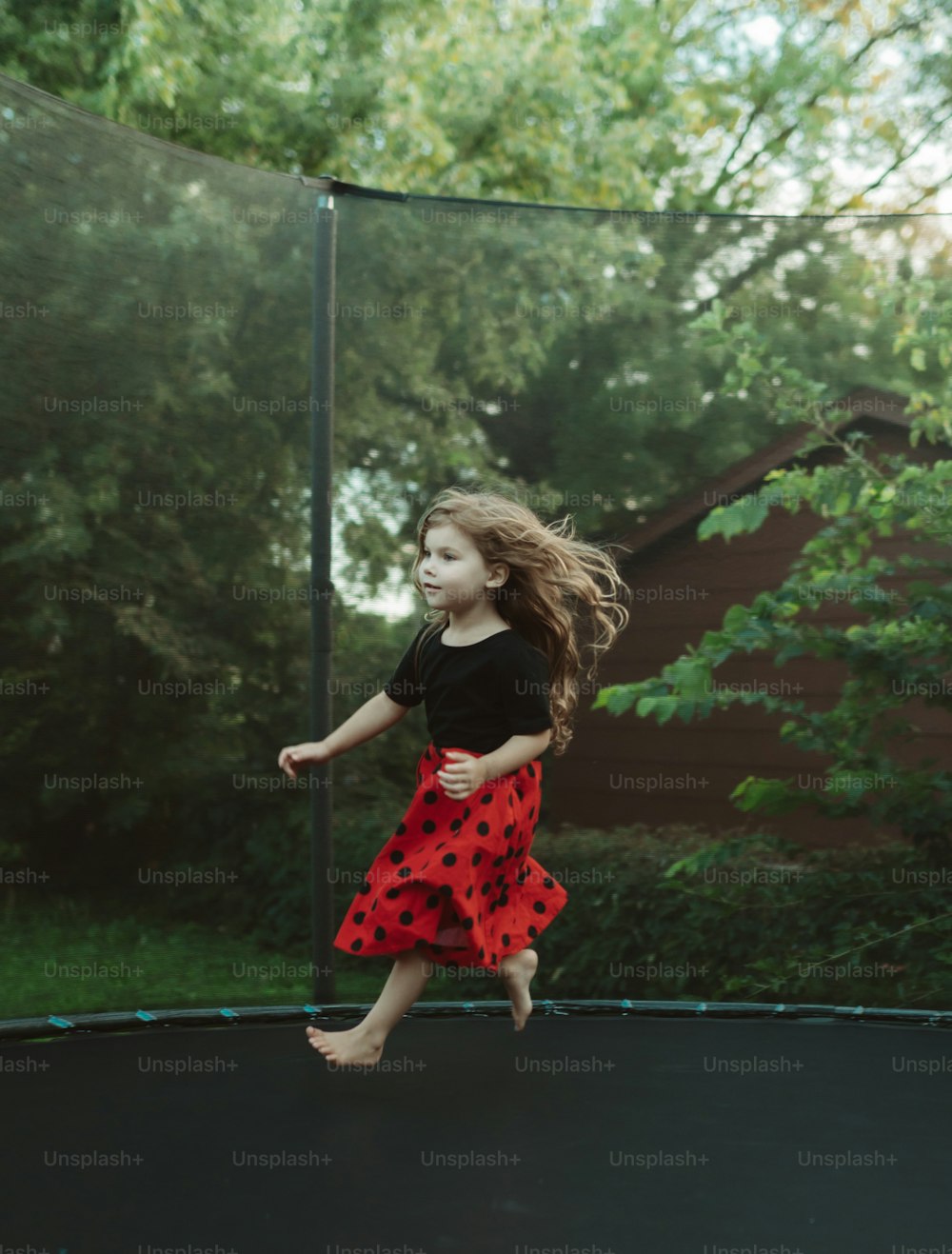 Una niña está saltando en un trampolín