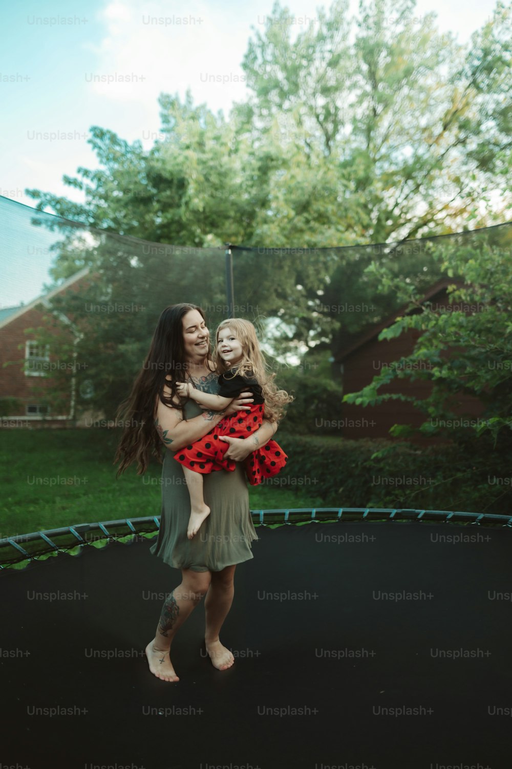 a woman holding a little girl on a trampoline