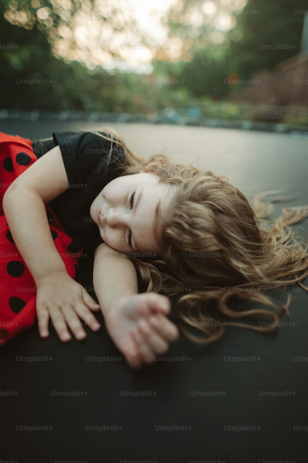 a little girl that is laying down on the ground