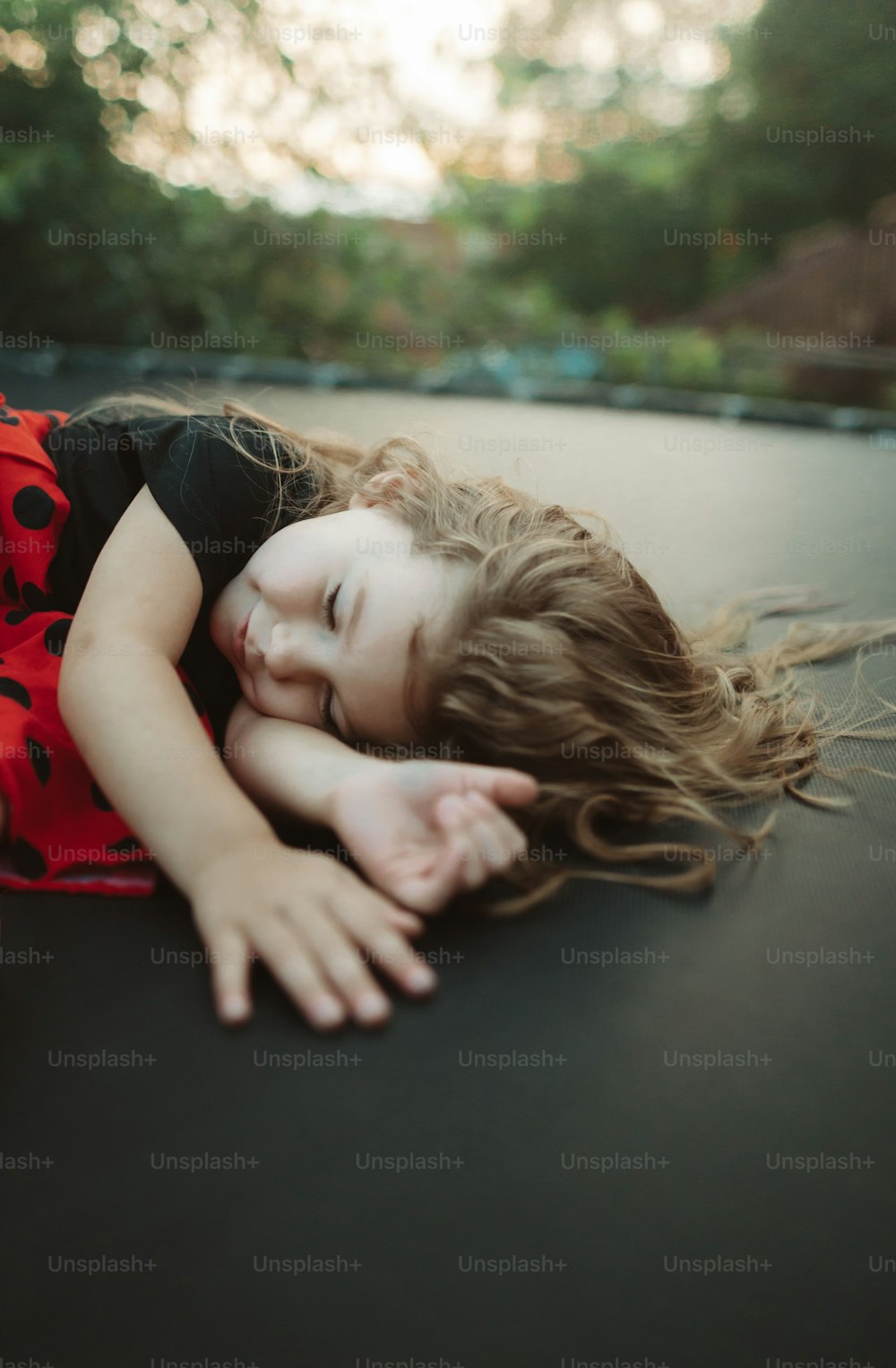 a little girl that is laying down on a trampoline