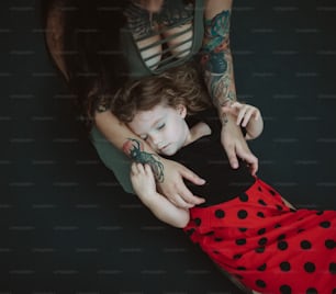 a woman holding a child with a tattoo on her arm