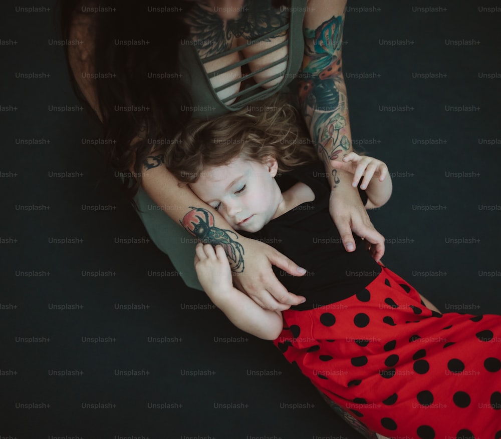팔에 문신이 있는 아이를 안고 있는 여자