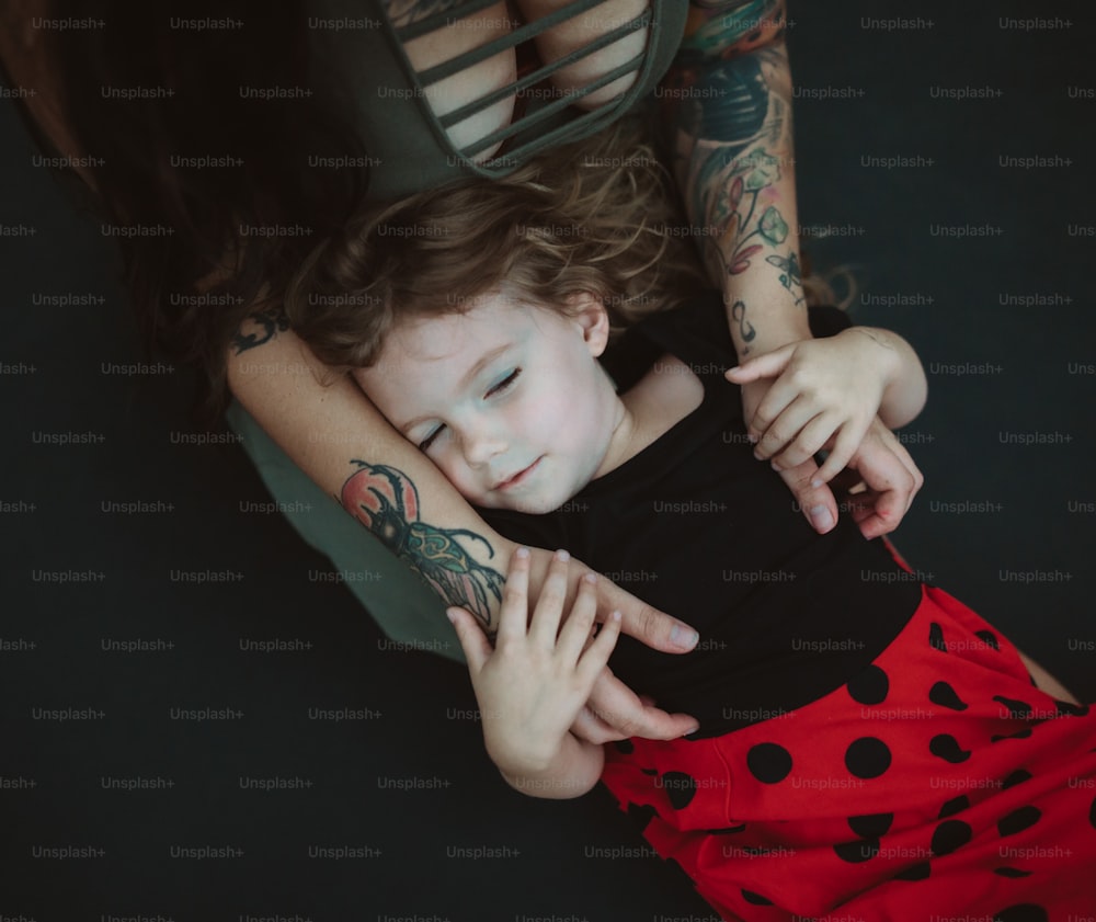 une petite fille allongée sur les genoux de sa mère