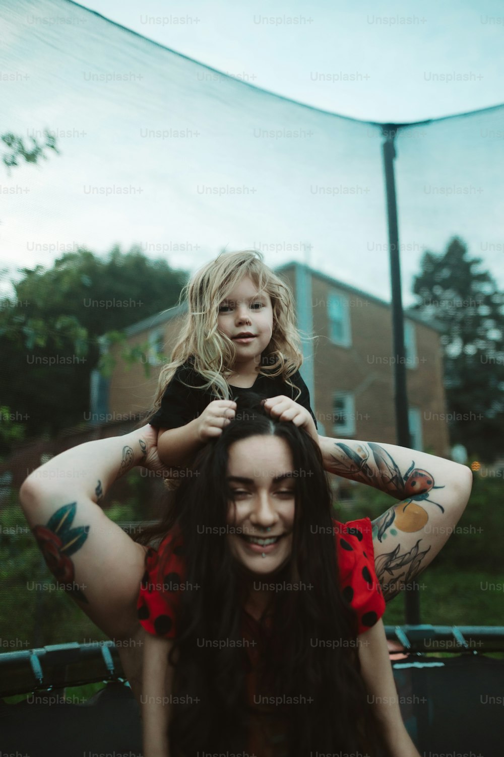 Una mujer sosteniendo a un niño en la parte superior de su cabeza