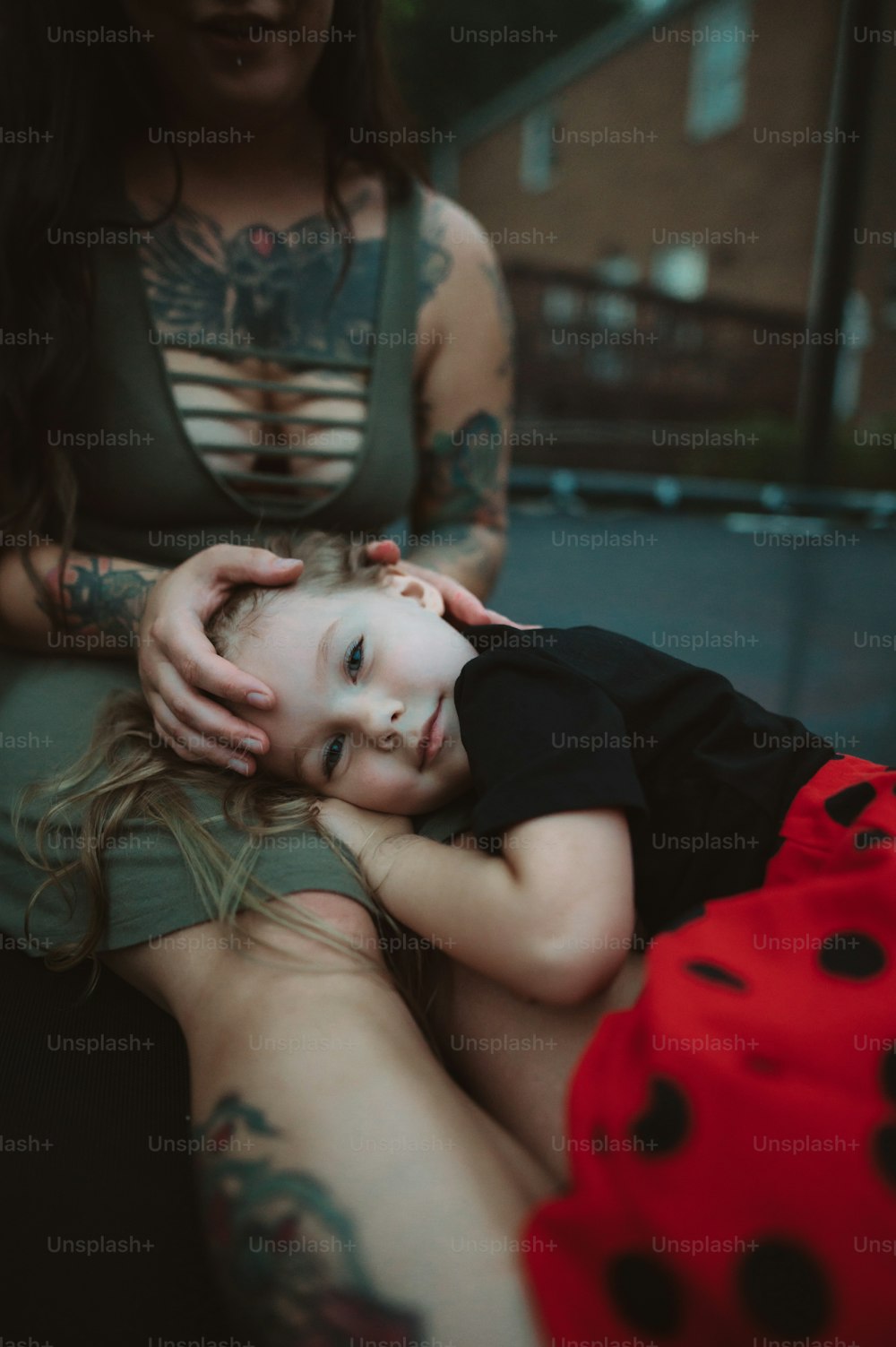 a little girl laying on her mother's lap