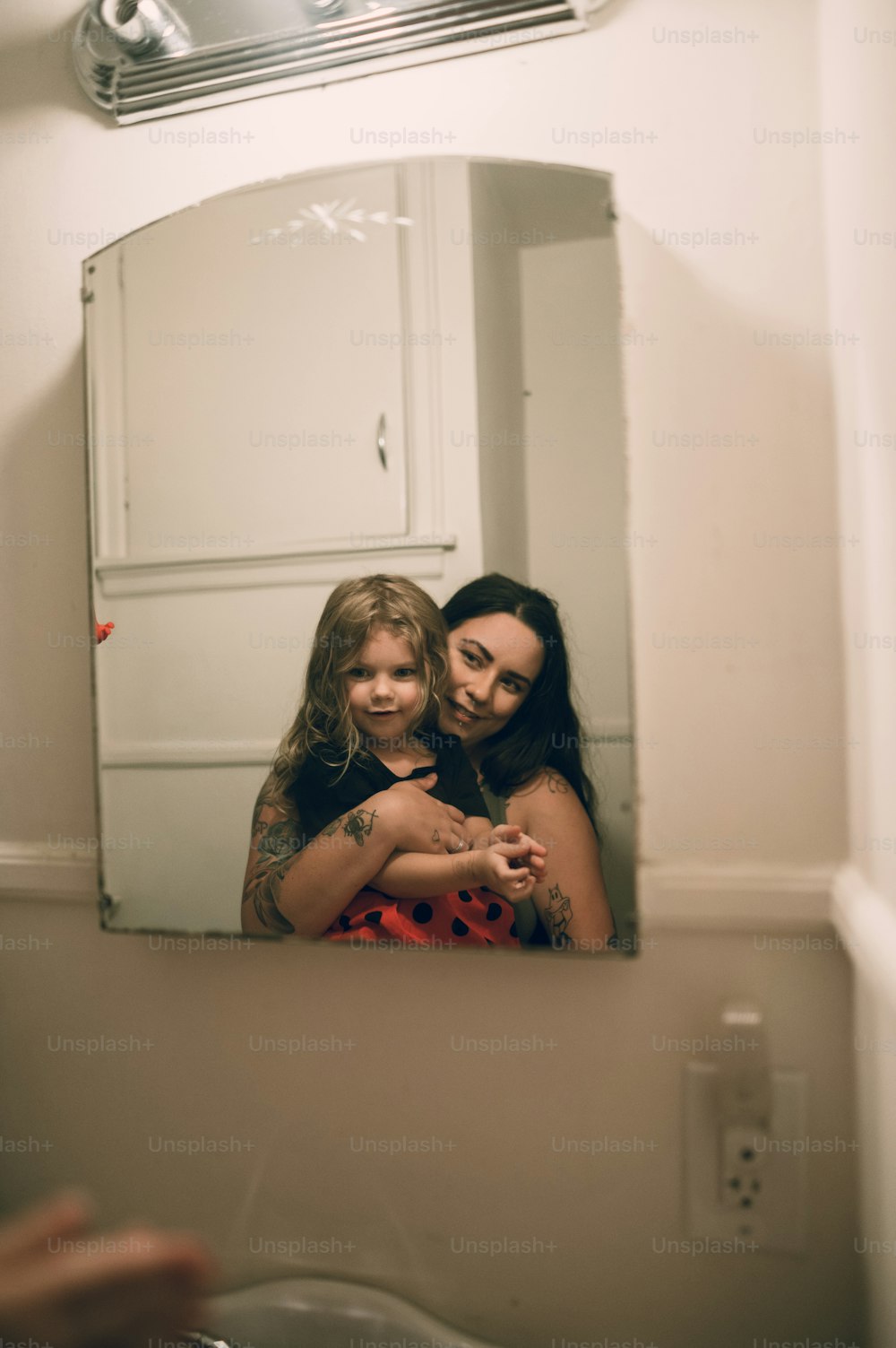 Eine Frau und ein kleines Mädchen schauen in einen Spiegel