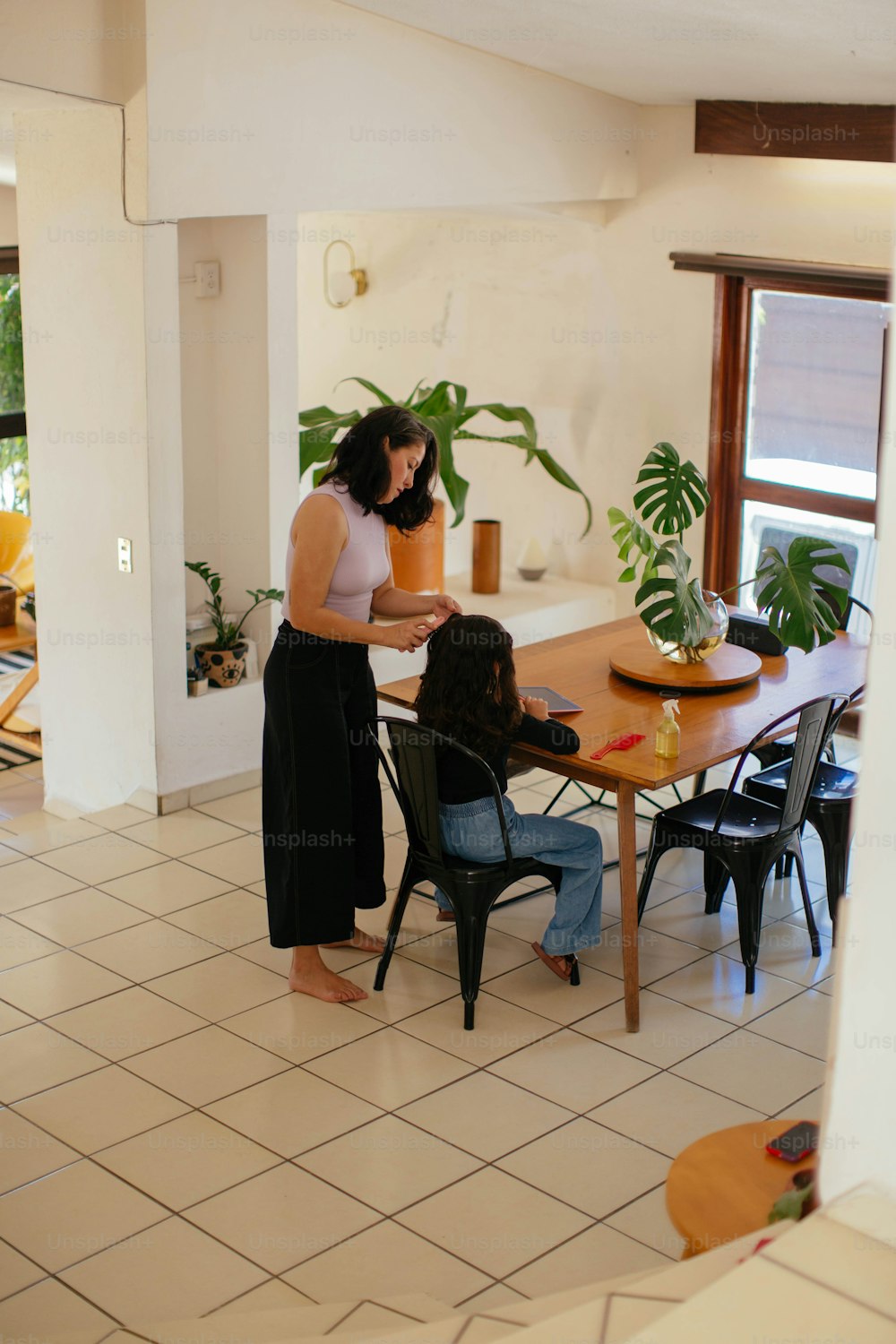 uma mulher em pé em uma cozinha ao lado de uma mesa